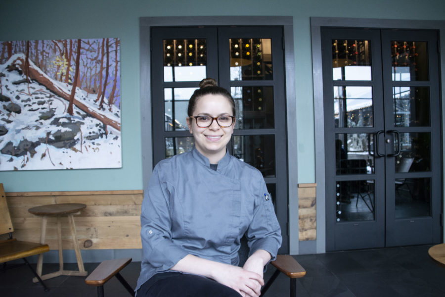 Win(e)ding down: Amis Trattoria executive chief Kiristina Wineski takes a break from the kitchen near the wine cellar. Wineski said her 60-hours-a-week is worth it but tiring.