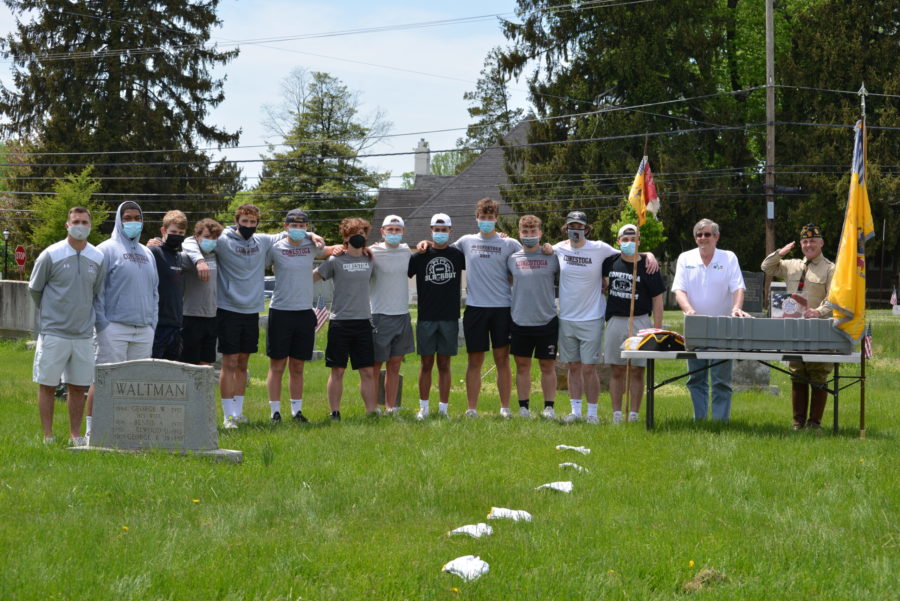 The football team stands with Head Coach Matt Diamond and members of the Legacy Marker Program in the graveyard of the First Baptist Church in Malvern. This photo was taken before they began refurbishing Samuel Paul Teamer’s grave. 