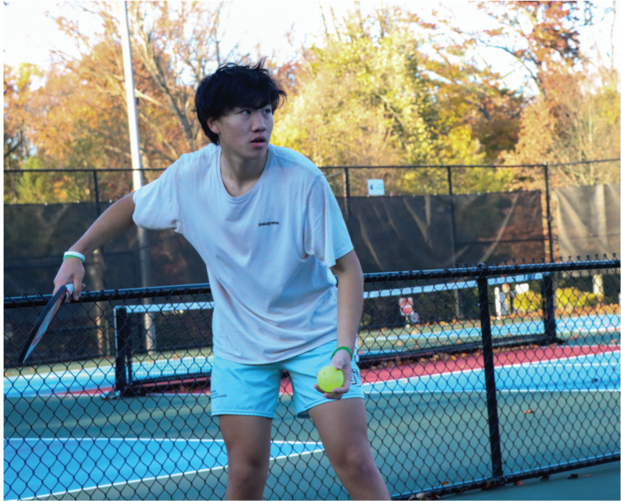Trying something new: Junior George Zhang serves the ball to begin a match. Initially disliking the sport, Zhang grew to recognize the skill that pickleball requires and now plans to play more frequently.