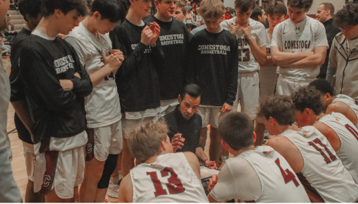 Talking tactics: Coach Sean Forcine speaks to the varsity boys’ basketball team about their strategy and performance during hal ime of a match against Upper Darby High School. The team held the lead for most of the game and won it with a final score of 70-66