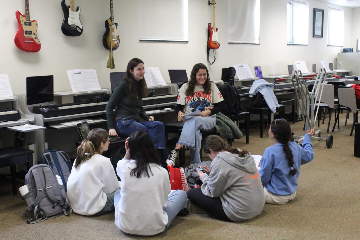 Lyrical lessons: Senior and Pitches Please president Ava Bruni (top right) leads the alto and soprano acapella group through a practice for its winter concert. Bruni’s experience at Treble Day in middle school inspired her to pursue high school choir. 