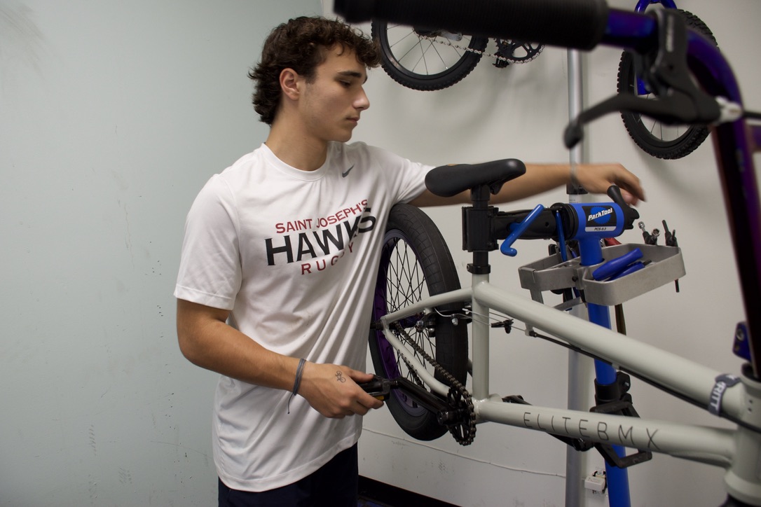 Hard at work: Sophomore Dom Pecora tunes a bike at his shop, Dom Fixes Bikes. Pecora launched his business when he was 10 years old and opened a shop in Malvern last year.