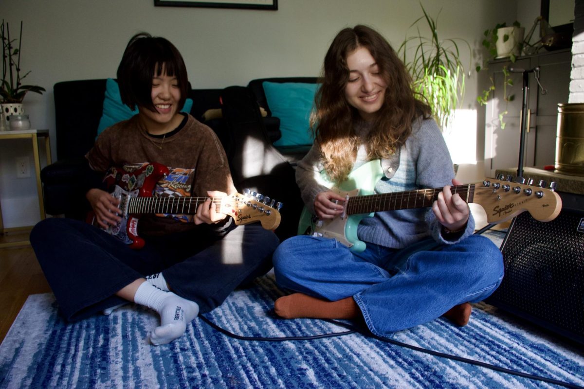 Perfect pair: Seniors Celine Luo and Penelope Valenti (from left to right) practice guitar together. The two played in Rittenhouse Square on Oct. 3. They will make monthly trips there to perform.