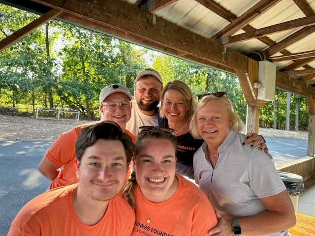 Fruitful fundraisers: Alumna Madison Niness (first from lower right) and Julie Niness (second from upper right), pose with their friends and family at the third annual Mark G. Niness Foundation golf outing and picnic. The foundation was created in memory of community member Mark Niness.