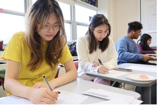 Letters for liberation: Juniors Hannah Vu (left) and Annabel Reeder (right) write letters at AmnestyxStoga’s Write For Rights Cornucopia event. Students wrote lettters during the campaign to liberate politial prisoners around the world.
