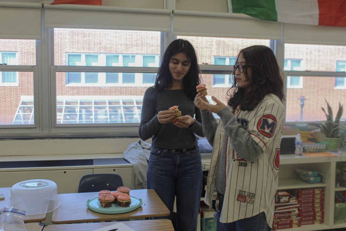 Keep calm and bake on: Sophomores Ananya Ahluwalia (left) and Montserrat Gonzalez-Rivas (right) try home-baked goods to potentially sell at the spring bake sale. Ahluwalia created the club last year.