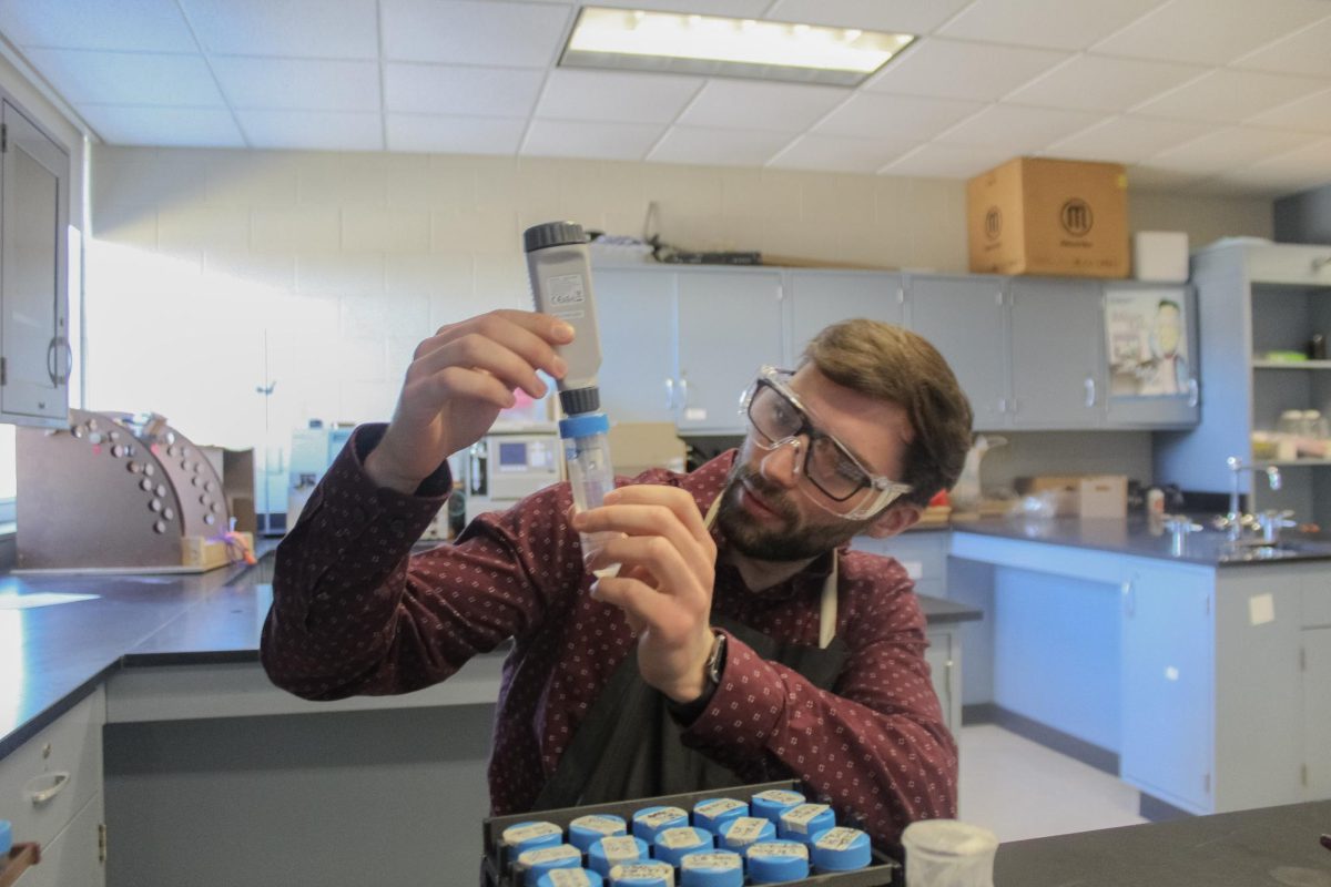 Yes to yeast: Biology teacher Derek Bosworth examines a yeast vial during eighth period Science Olympiad. Bosworth started researching yeast in 2022 and has worked with senior Mahlon Bierly throughout the year.