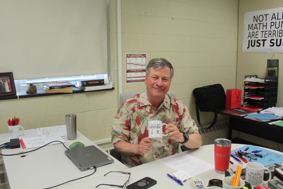 Poised to learn: Math teacher Paul Poiesz sits at his desk and displays his mug with a math pun. Poiesz began teaching at Conestoga 28 years ago after teaching at Bishop McDevitt High School. He will retire at the end of this school year, wrapping up his 43-year teaching career.