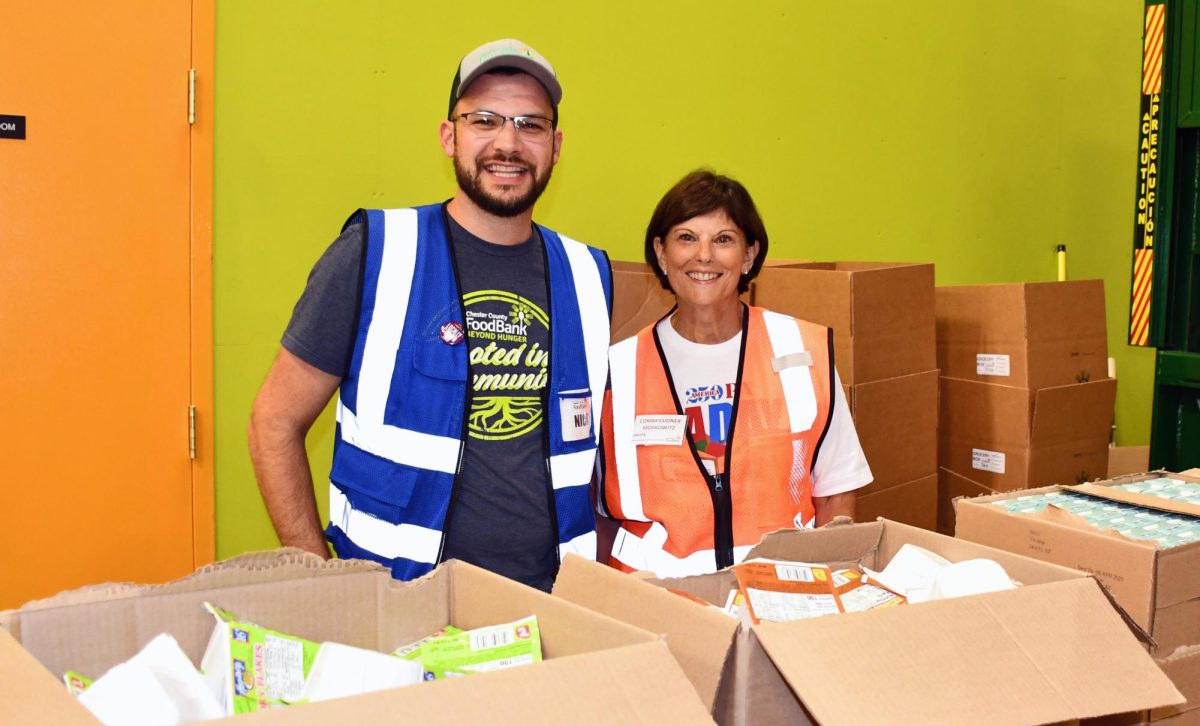 Fun distributing food: Chester County Food Bank Director of Community Relations Nicholas Imbesi (left) and Chester County Commissioner Marian Moskowitz (right) package food donations from the Chester County Steps Up Initative’s food drive. The drive lasted a month and raised 692 pounds of food and $760. 