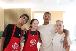 Cultural cooking: Senior Elle Farabaugh (second from left) smiles with her friends from Children’s International Summer Villages (CISV) after cooking lunch together. Farabaugh joined CISV in 2021 and went to Vienna, Austria this summer for three weeks as part of the program.