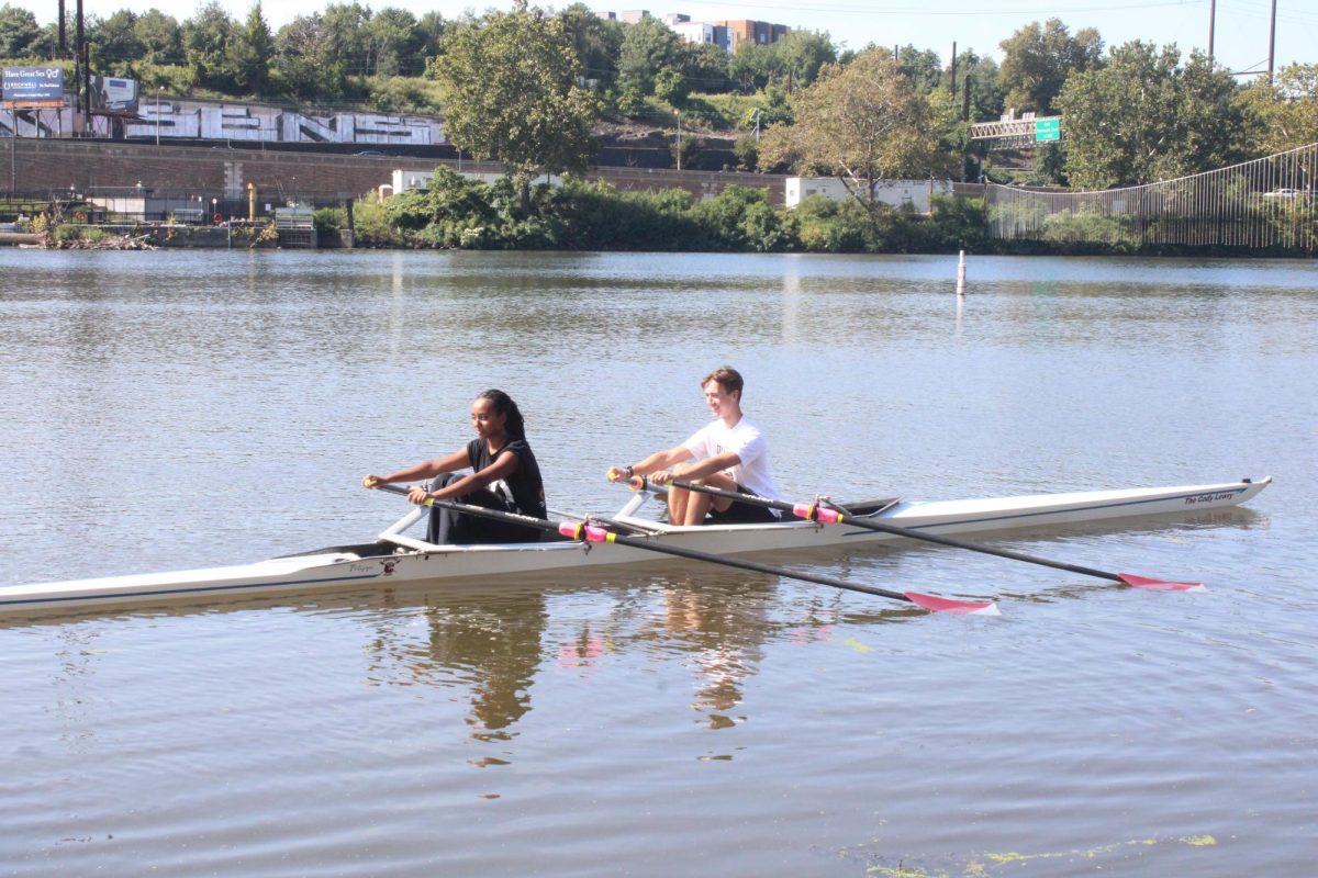 Balanced blades: Senior Sosi Sengal (left) positions her oars to match those of senior Hudson Dunkle (right). On Sept. 14, Dunkle taught Sengal how to enter the scull and row with proper form at the Drexel University boathouse on the Schuykill River in Philadelphia. 