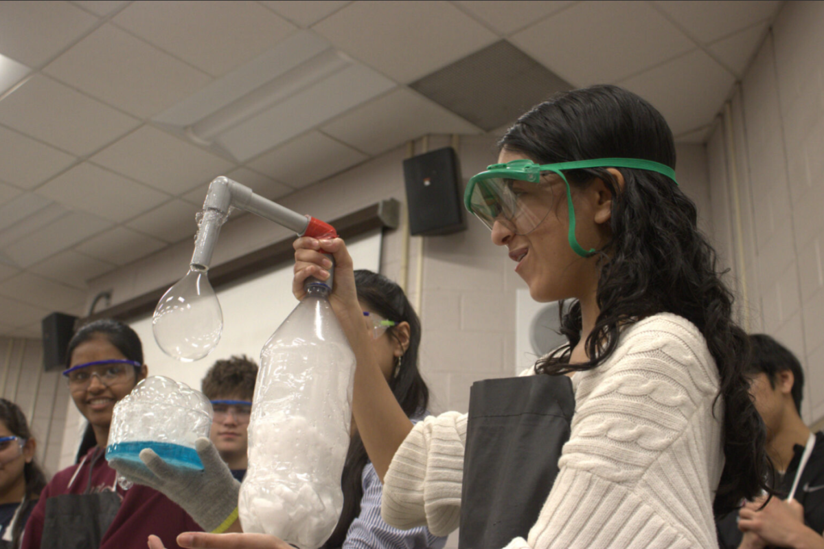 Beautiful bubbles: Junior Karina Shah demonstrates a bubbles experiment using carbon dioxide and dish soap. Chemistry Club members visited Devon Elementary School on Feb. 13 to conduct demonstrations for the students.
